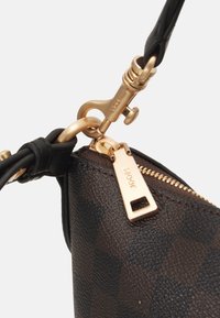 Borsa a mano marrone con motivo, finitura testurizzata, hardware dorato e chiusura con zip dotata di tirazip brandizzato e attacco in pelle per la tracolla.