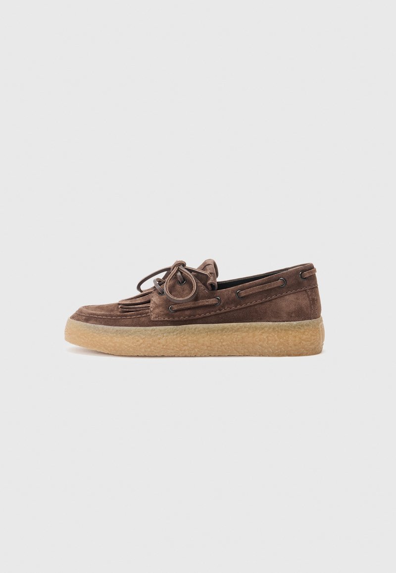Brun semsket båt sko med en moccasin-inspirert design, gummisåle og dekorative lisser. Har en glatt tekstur og rund tåform.