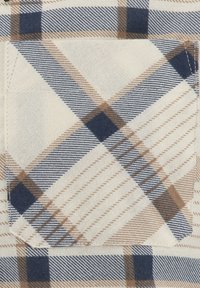 Tessuto a quadri con colori bianco, blu e beige. Presenta una tasca con cucitura rinforzata e una finitura morbida e testurizzata.