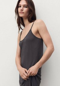 Gray sleeveless dress with thin straps, soft fabric, relaxed fit, slightly draped design, minimalistic style, seamless neckline.