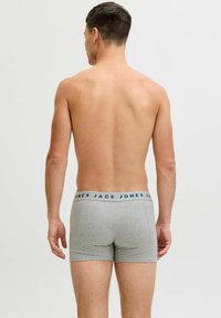 Harmaat bokserit, joissa on kontrastivärinen joustovyö, jonka päällä on brändin nimi "JACK & JONES" sinisellä. Sujuva kangasrunko.