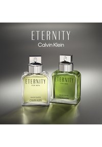 To kvadratiske flasker av Calvin Klein sin "Eternity for Men", den ene med en klar glasskropp og grønn væske, den andre med en klar glasskropp og gul væske.