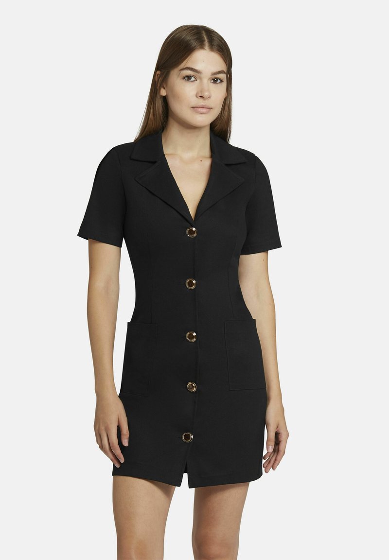 Schwarzes, tailliertes Kleid mit kurzen Ärmeln, eingeschnittenem Kragen, fünf goldfarbenen Knöpfen und zwei vorderen Taschen. Glatte Textur und maßgeschneiderte Design.