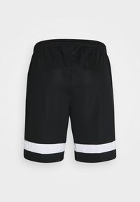 Shorts de sport noirs avec ceinture élastique et larges bandes blanches près de l'ourlet sur chaque jambe, vus de dos.
