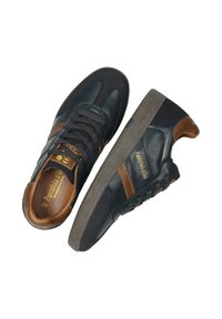 Zapatillas de cuero negro con detalles en marrón, diseño con cordones, suela de goma texturizada y detalle de logo dorado en la plantilla y el lateral.