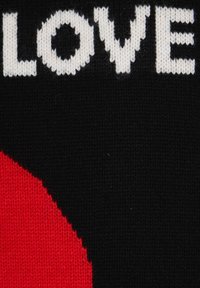 Tessuto a maglia nero con grande testo bianco che scrive "AMORE" e una forma circolare rossa audace integrata nel design.