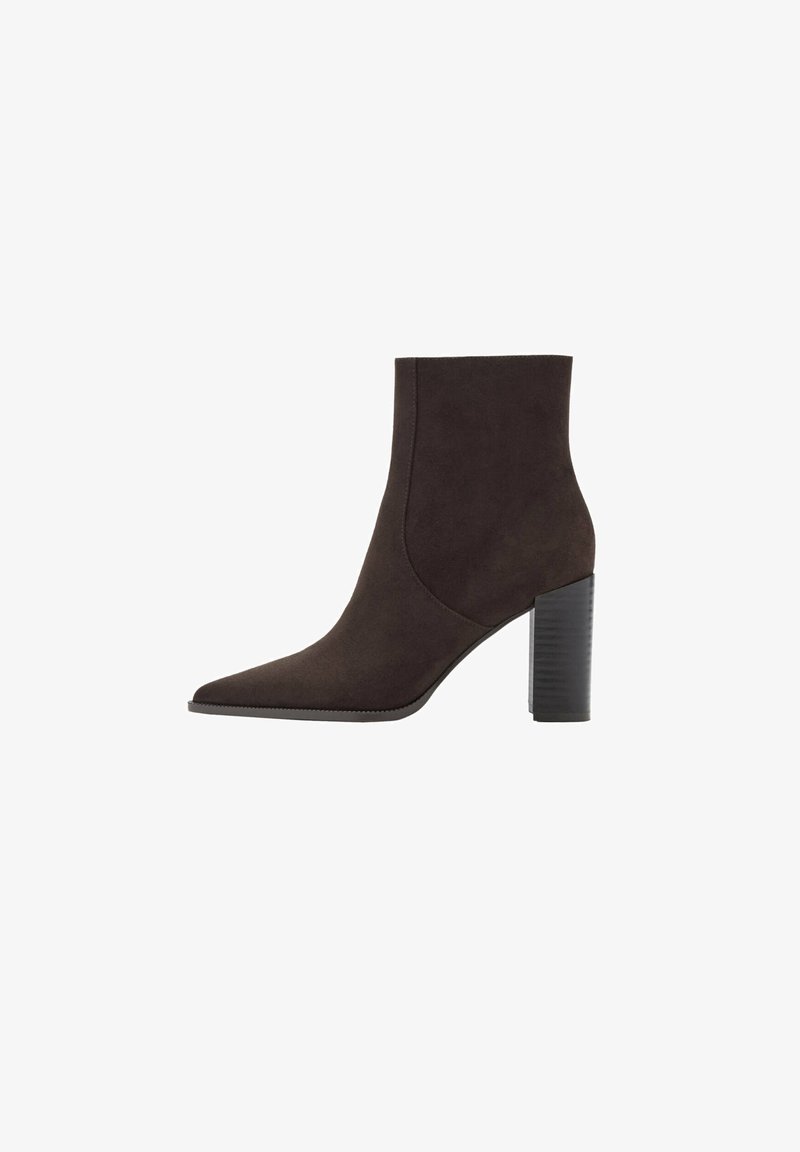 Bottine noire en daim avec bout pointu et talon haut bloc, montrée de profil sur un fond blanc.
