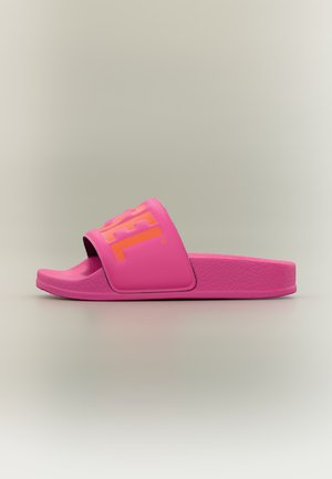 Sandalia tipo chancla de color rosa brillante con una amplia correa que muestra texto parcial en naranja de la marca, suela texturizada y dedo abierto sobre un fondo neutro.