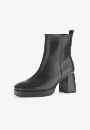 Schwarze Lederstiefelette mit runder Zehenkappe, einem klobigen hohen Absatz und einem Reißverschluss auf der Rückseite. Besitzt eine glatte Oberfläche und ein minimalistisches Design.