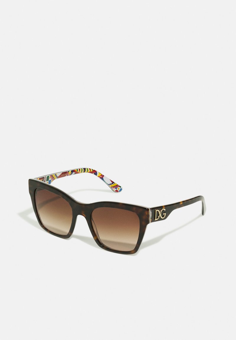 Gafas de sol de gran tamaño en forma cuadrada con montura de carey, lentes marrones degradados y una patilla de diseño colorido que presenta un acento en oro.