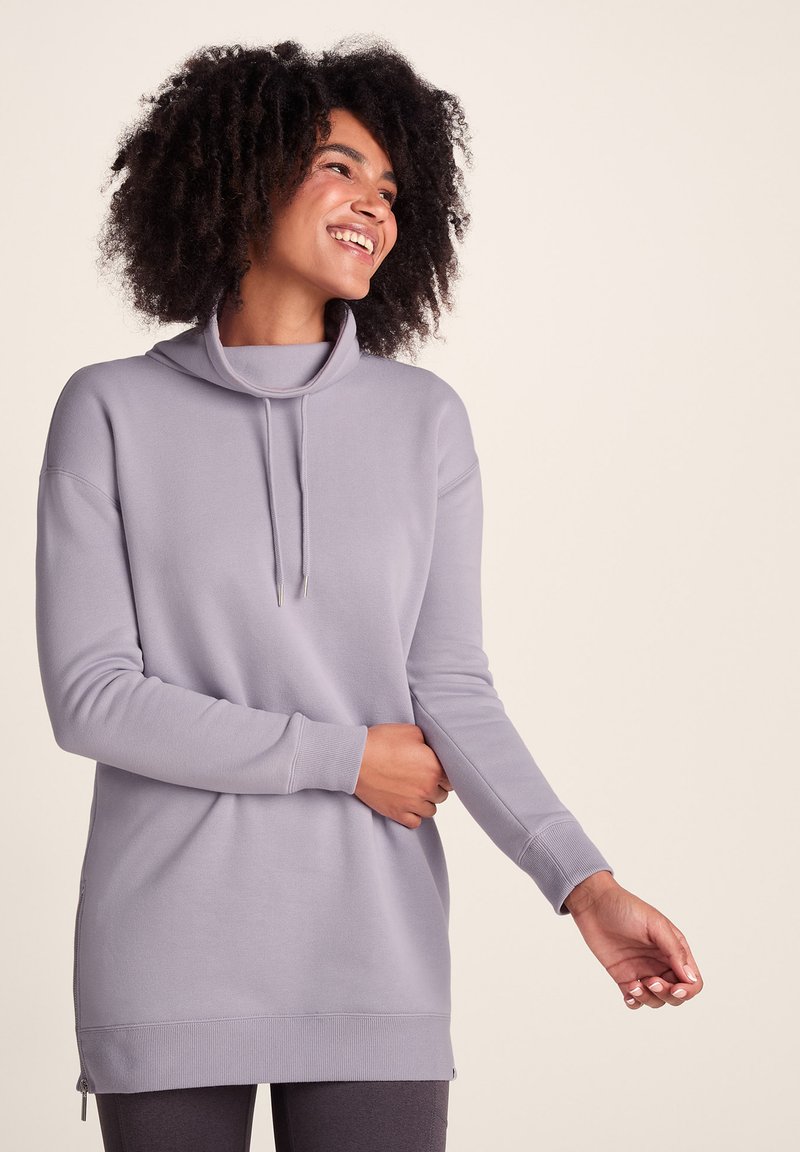Light gray sweatshirt with a cowl neck, long sleeves, and side zippers. Soft texture, relaxed fit, and ribbed cuffs and hem.