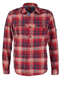 Chemise à carreaux rouge, marine et blanche à manches longues avec poches poitrine boutonnées et col, présentée sur fond blanc.