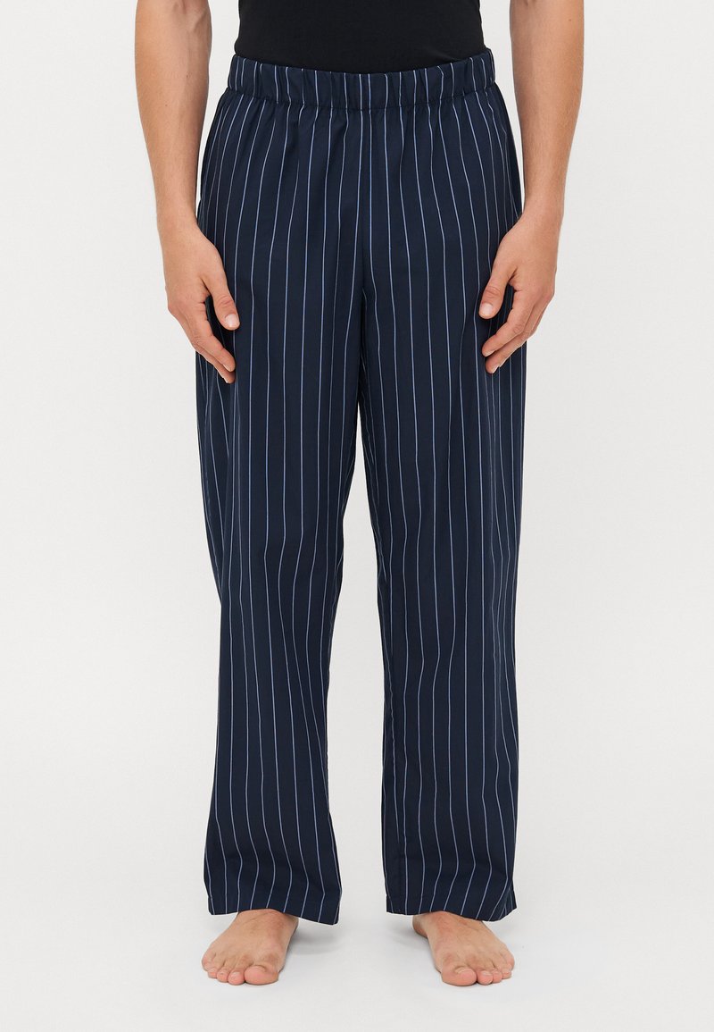Marineblauwe gestreepte broek met een elastische tailleband, voorzien van dunne witte verticale strepen, een losse pasvorm en een soepele, lichte stof.