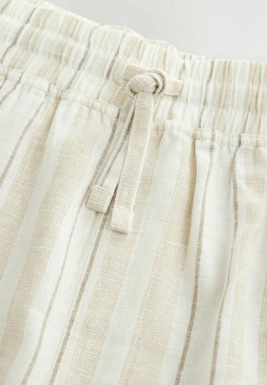 Lekkie, beżowe i białe szorty w paski z elastyczną talią i detalem sznurka, charakteryzujące się teksturowanym materiałem.