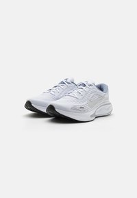 White athletic shoes with mesh upper, silver accents, and black sole. Features lacing system and cushioned midsole for support.