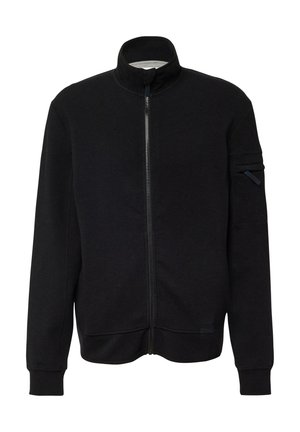 Schwarze Jacke mit Reißverschluss aus Baumwollmischgewebe, mit hohem Kragen, Seitentaschen und einer Reißverschlusstasche am oberen Ärmel. Glatte Textur.