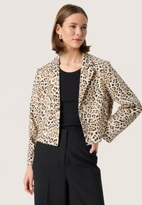 Løveprint blazer i brune og sorte nuancer, med en skræddersyet pasform, klippede lapeller, lange ærmer og en glat tekstur. Sammen med en sort top.