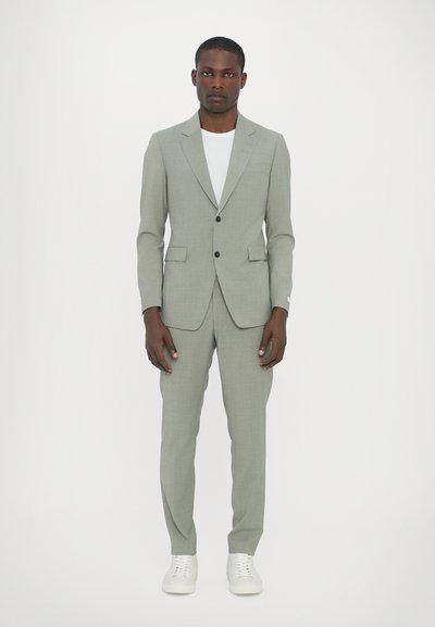 Light gray suit with a tailored design, single button closure, and notch lapels, paired with a white t-shirt and white sneakers.