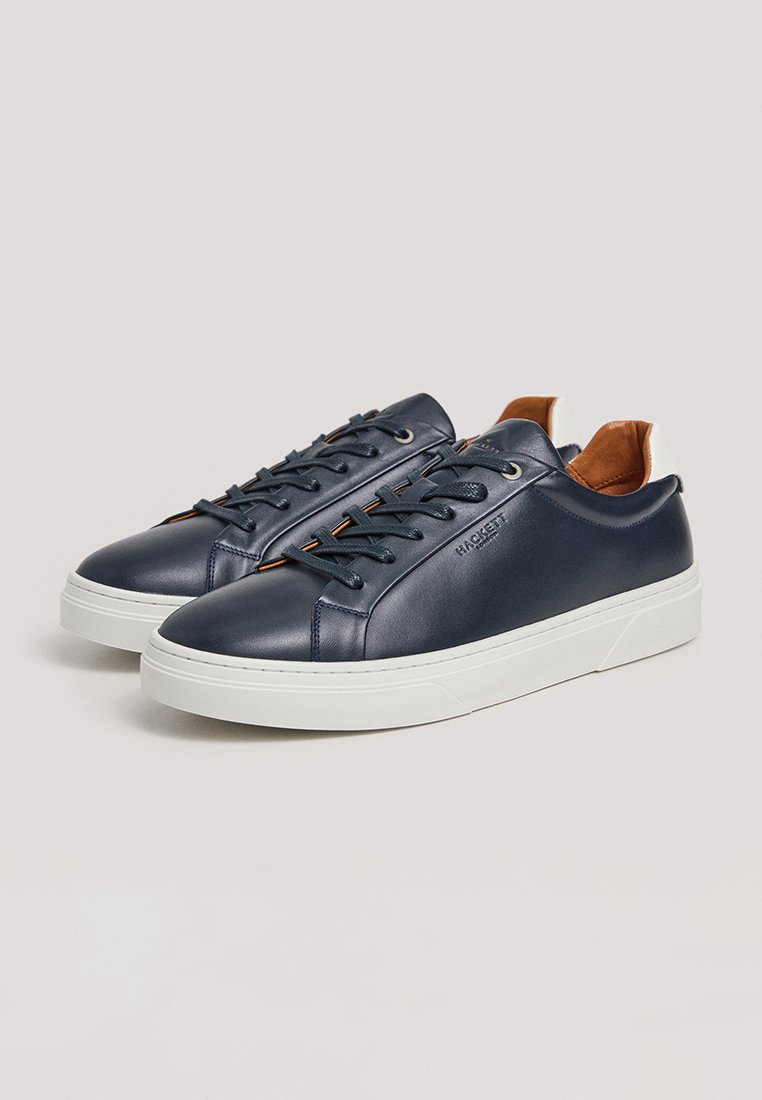 Baskets en cuir navy avec semelle en caoutchouc blanche, accents cousus et doublure intérieure marron. Caractéristiques : bout rond et design classique à lacets.