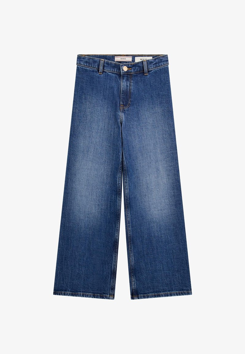 Jean denim bleu à jambes larges avec bouton et fermeture éclair à l'avant, passants pour ceinture, et légère décoloration sur les cuisses, posé à plat sur un fond blanc.