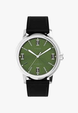 Timex automatinis laikrodis su žaliu tekstūruotu ciferblatu, sidabriniais indeksais ir rodyklėmis, juoda odinė apyrankė ir datos rodymas 6 val. pozicijoje.