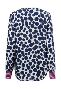 Blusa a maniche lunghe bianca con pois blu navy, con polsini a strisce rosa e bianchi. Tessuto morbido con una vestibilità comoda.