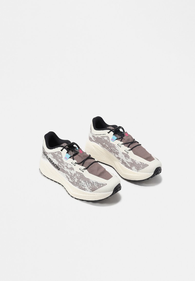 Een paar wit-grijs gevlekte atletische hardloopschoenen met zwarte veters en dempende zolen op een witte achtergrond.