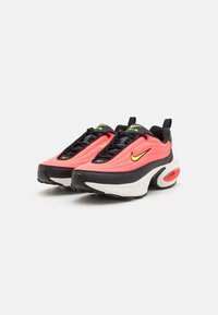 Athletic sneakers with a pink and black fabric upper, Nike swoosh, black laces, and a white sole featuring a visible air unit.