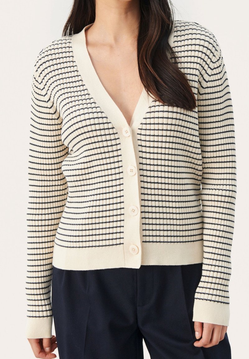 Cardigan crema con righe orizzontali blu navy, scollo a V, texture a costine e cinque bottoni chiari sul davanti. Maniche lunghe.