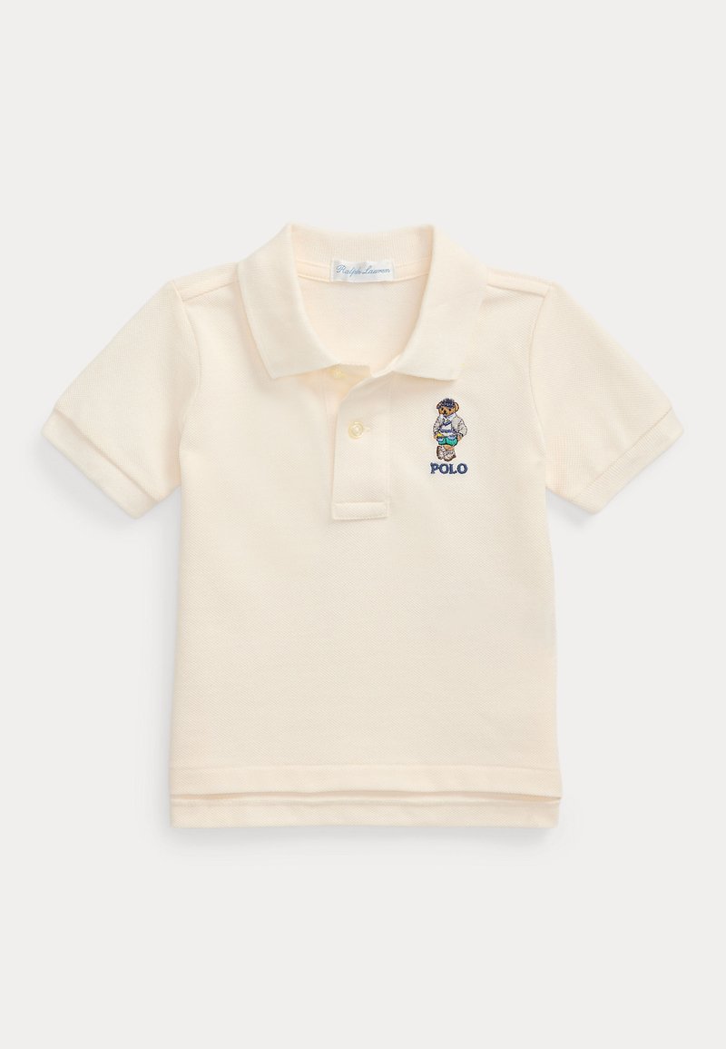 Camisa polo em tecido de algodão cor creme, com colarinho dobrado, mangas curtas e um logótipo bordado no peito.