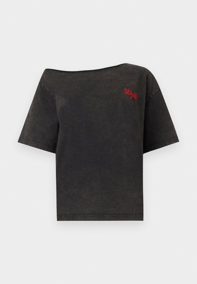 Μαύρο T-shirt με κοντά μανίκια και ακάλυπτους ώμους με κόκκινη κέντημα "Steglitz" στο αριστερό στήθος, εμφανίζεται σε λευκό φόντο.