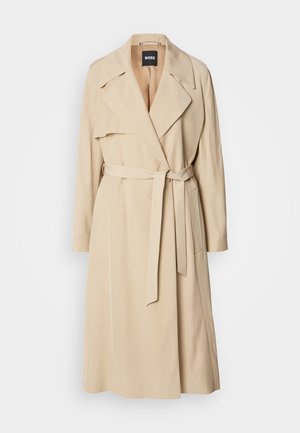Beige trenssitakki, joka on valmistettu sileästä kankaasta, sisältää kaksirivisen designin, leveät kaulukset, vyön vyötäröllä ja sivutaskut.