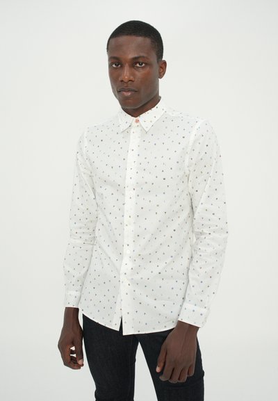 White button-up shirt with multicolored letters printed throughout. Features a classic collar and long sleeves, paired with dark jeans.