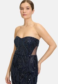 Granatowa sukienka bez ramiączek z misternym haftem i floralnymi wzorami. Posiada przezroczyste boczne panele. Dopasowana sylwetka o teksturowanym wykończeniu.