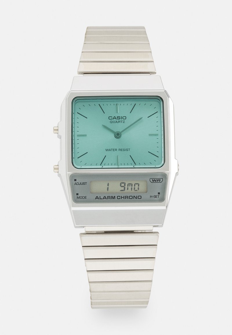 Montre-bracelet en métal argenté avec un cadran rectangulaire, un cadran bleu clair, un affichage analogique, un panneau numérique et un bracelet en acier inoxydable. Résistante à l'eau.