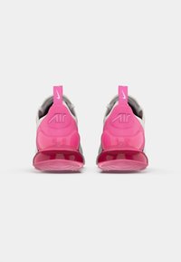 Rózsaszín és szürke Nike Air sportcipők átlátszó rózsaszín Air talppal, texturált felsőrésszel és hangsúlyos márkalogóval a sarkon.