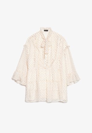 Blusa branca com punhos franzidos e laço ao pescoço. Apresenta um padrão dourado pontilhado. Mangas compridas e caimento solto, fabricada em tecido leve.