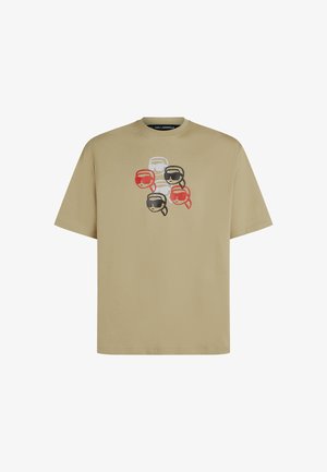 Karamelio spalvos medvilninė marškinėlių su šešiais stilizuotais veidais, dėvinčiais akinius nuo saulės, raudonos, juodos ir baltos spalvos. Standartinė iškirptė, apvalios iškirptės dizainas.