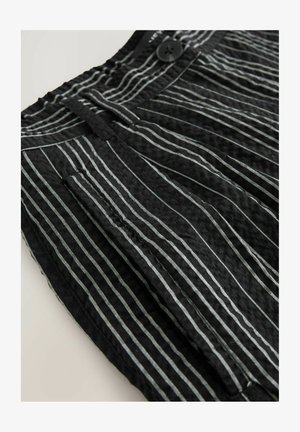 Black fabric shorts with vertical white stripes, featuring pleats and a front button closure. Texture appears crinkled, emphasizing the patterns.
