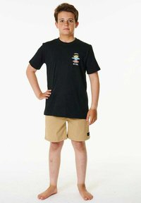 T-shirt noir à manches courtes avec un logo graphique coloré, associé à un short beige. Tissu léger, coupe décontractée, fond uni.