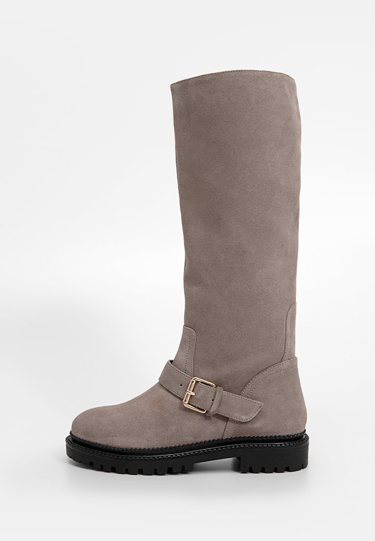 Graue Wildleder-Stiefel bis zum Knie mit flacher Sohle, ausgestattet mit einem Schnallenakzent am Knöchel und einer strukturierten Oberfläche.