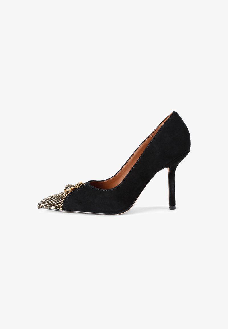 Black suede high-heeled pump with pointed toe, featuring a metallic studded accent at the toe cap and a thin heel. Smooth interior lining.