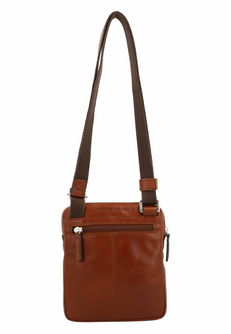 Braune Leder-Schultertasche mit texturiertem Oberfläche, verstellbarem Trageriemen und einem frontalen Reißverschlussfach. Mit silbernem Beschlag und rechteckiger Form.