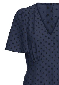 Robe bleu marine en tissu texturé, avec des pois noirs en relief, manches courtes bouffantes et décolleté en V.