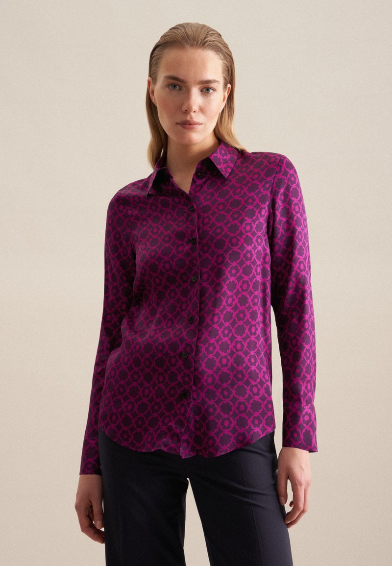 Camicia fucsia con un motivo geometrico, design con colletto, maniche lunghe e chiusura con bottoni. Texture liscia con una silhouette aderente.