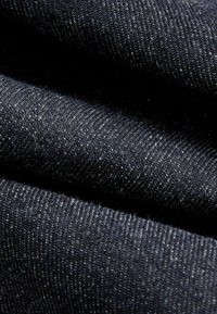 Tume sinine denimriie sujuva tekstuuriga, millel on peen kudumis muster ja hõbedased täpid üle kogu pinna.