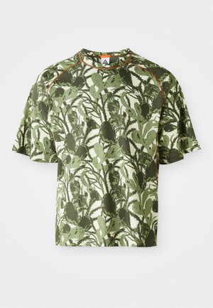 Camiseta verde de manga curta com um padrão de folhas texturizadas, apresentando um destaque laranja na gola e um corte descontraído. Feita de material respirável.