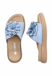 Helle blaue Rutschen mit einer strukturierten, tanfarbenen Sohle, die große Stoffblumenakzente an den Riemen aufweisen. Weiches Lederobermaterial, gepolsterte Fußbett.