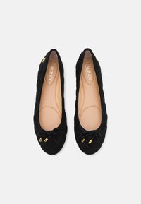 Zwarte gewatteerde ballerina's met een ronde neus, een decoratieve strik en goudkleurige hardware. Zacht binnenvoetje en een gladde buitenkant.