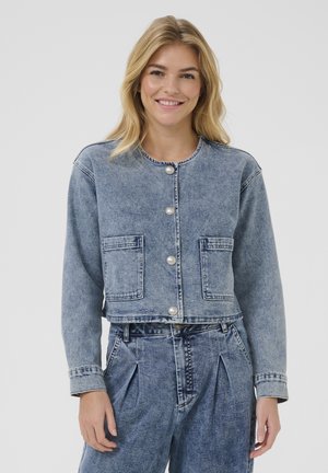 Skórzana kurtka z denimu w jasnoniebieskim odcieniu, okrągłym dekoltem, z przodu zapinaną na perłowe guziki i dwoma kieszeniami z przodu z przeszyciami.